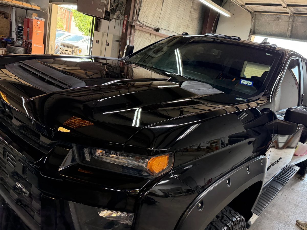 Chevy Silverado hood after paintless dent repair at DG Collision Center Lewisville TX &mdash; metal finished level, factory paint untouched
