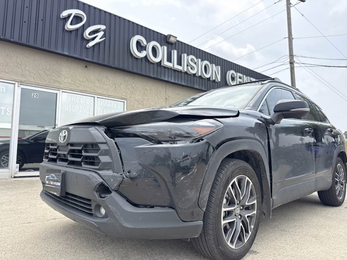 Front-end collision damage before repair — Toyota RAV4 with front bumper and headlight damage at DG Collision Center Lewisville TX