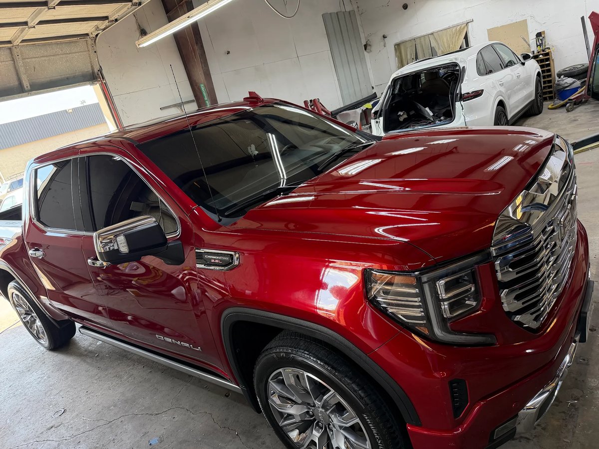 Red GMC Sierra Denali gleaming after full-vehicle hail repair at DG Collision Center Lewisville TX