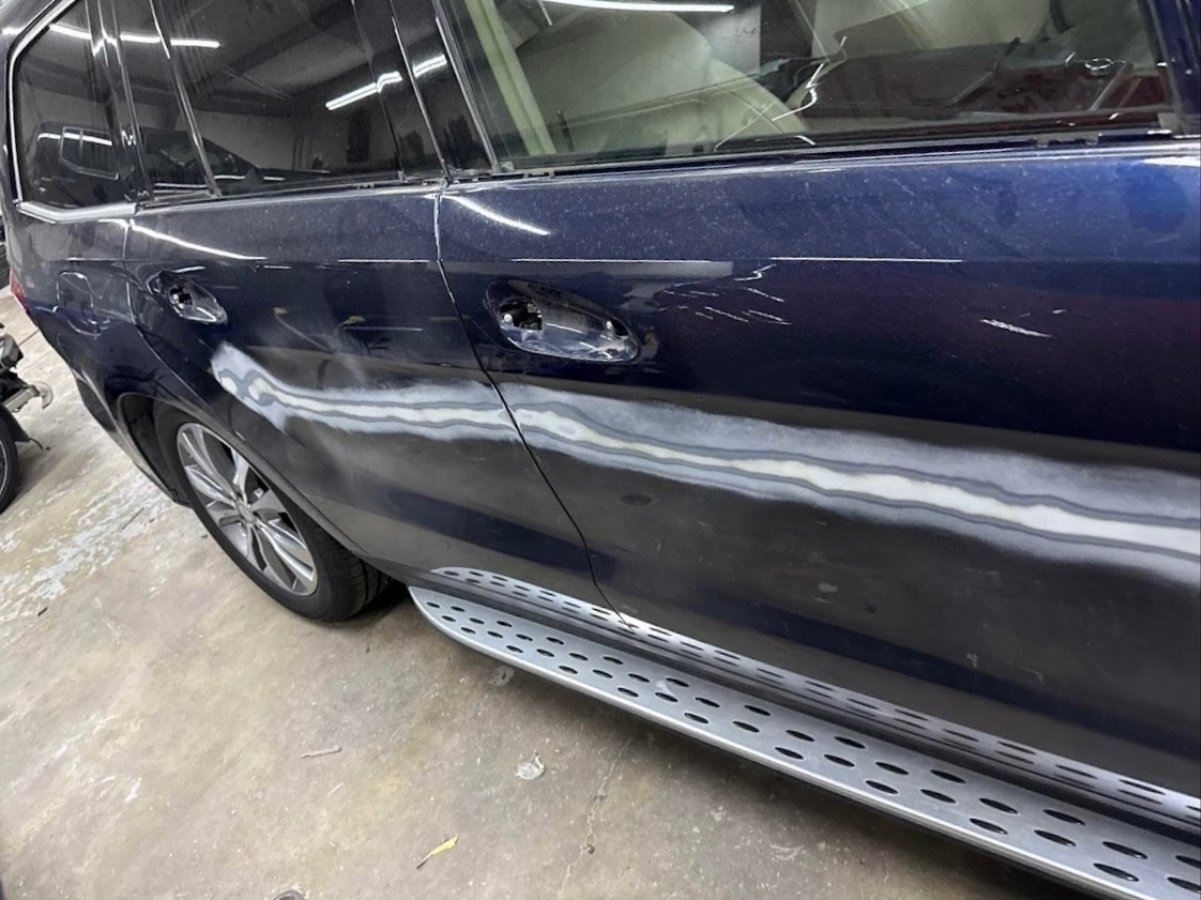 Customer's Mercedes-Benz GLS with scraped and dented doors before repair at DG Collision Center Lewisville TX
