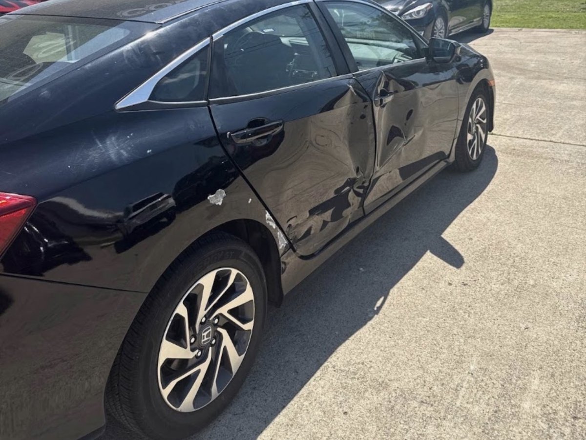 Honda Civic with side-impact collision damage before repair at DG Collision Center Lewisville TX — dented doors and quarter panel